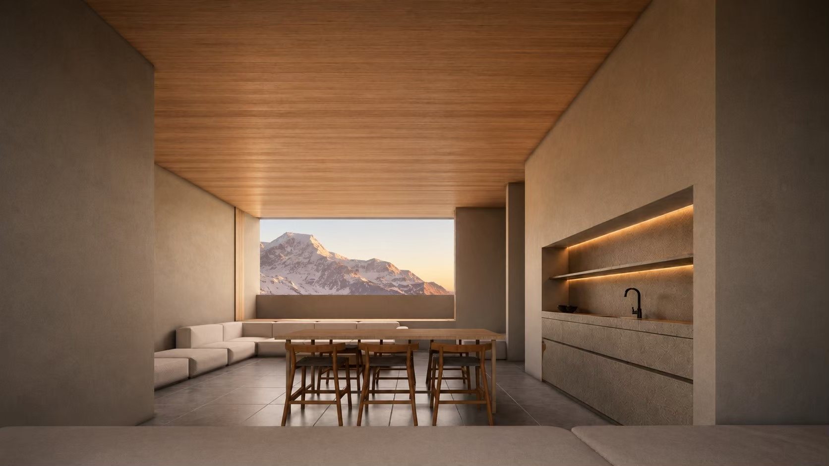 A dining room at dusk, facing a snow-covered mountain